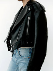 Women’s faux leather short motorcycle jacket with belt, zipper lapel, and loose fit, styled for spring and autumn wear.