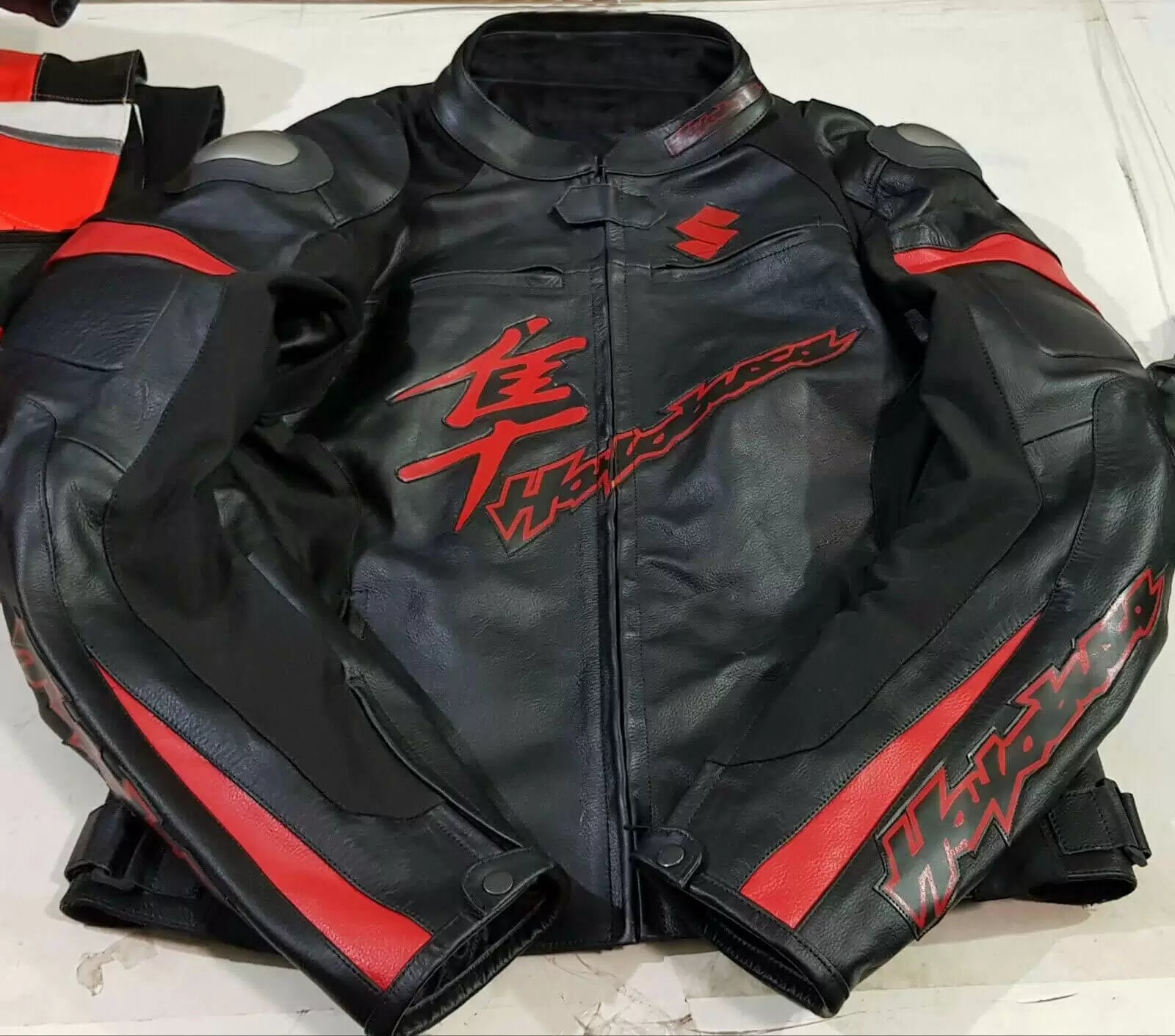 Red and black Suzuki Hayabusa motorcycle jacket by DAMOTOGEAR with protective armor and stylish design.