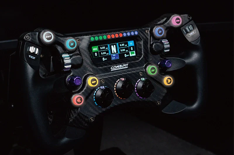 Front view of the Trak Racer UK Conspit 300GT steering wheel with black grips and metal spokes, mounted on its base.