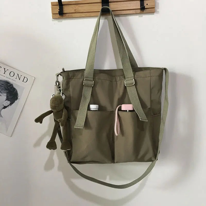 Women’s Adistore shopper bag with zipper, featuring a solid design, crossbody strap, and tote shoulder handle for versatile use.