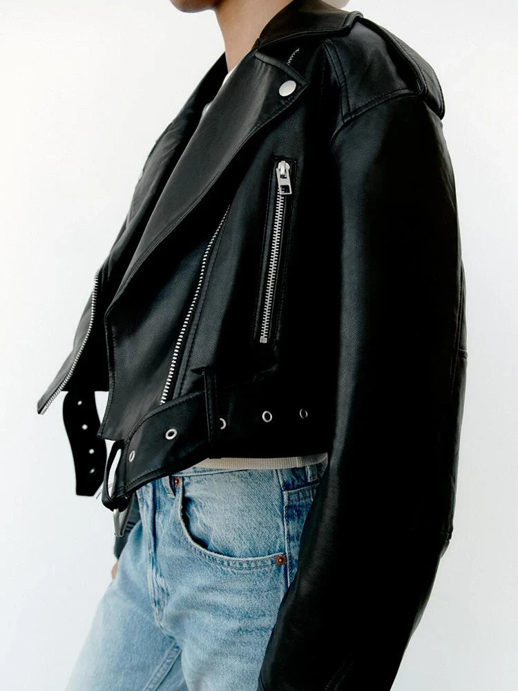 Women’s faux leather short motorcycle jacket with belt, zipper lapel, and loose fit, styled for spring and autumn wear.