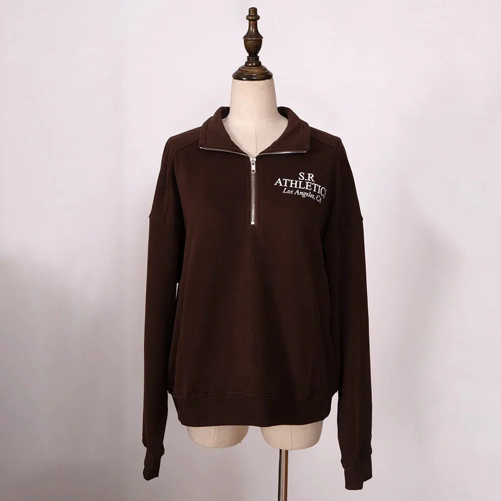 Women's ZESSAM Club graphic sweatshirt by Adistore featuring long sleeves and a collar, shown on a model.
