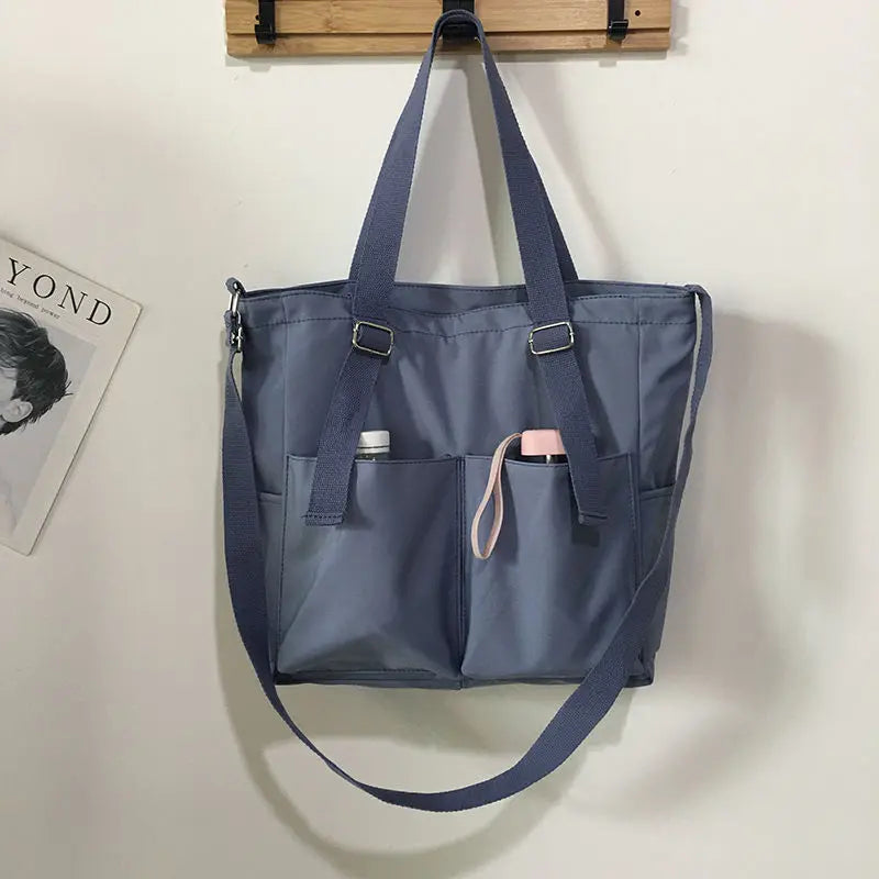 Adistore women's shopper bag with zipper, featuring a solid design, crossbody and tote shoulder styles, shown in black.