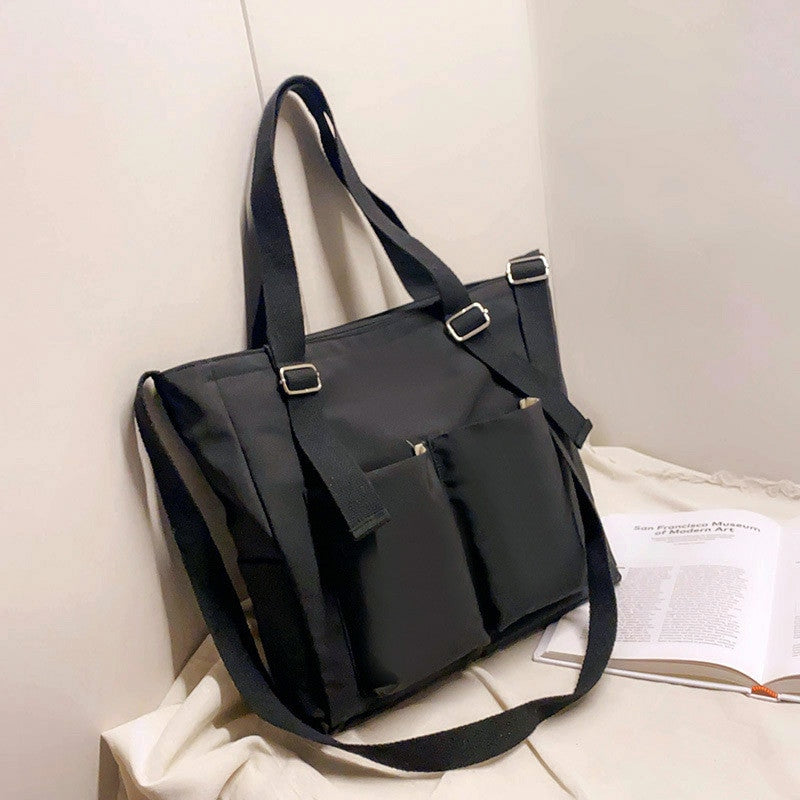 Adistore women's shopper bag with zippered solid design, versatile crossbody and tote shoulder bag in black fabric.
