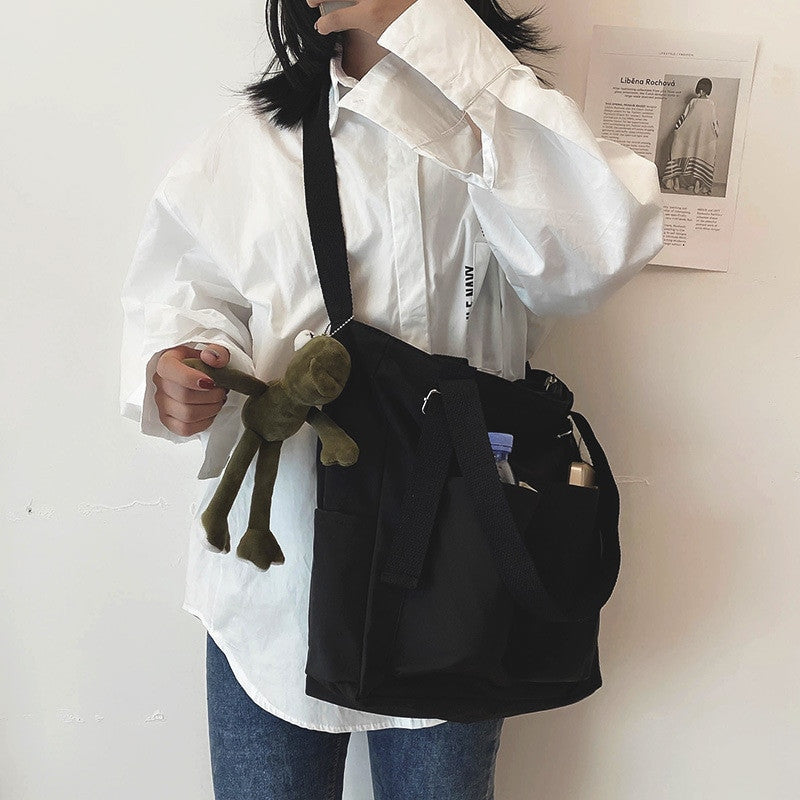 Adistore women's shopper bag with zippered solid design, featuring a crossbody and tote shoulder style, shown in black.