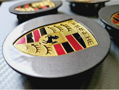 Grey Porsche wheel centre caps with Eliteridegear branding, featuring sleek design and durable finish for vehicle enhancement.