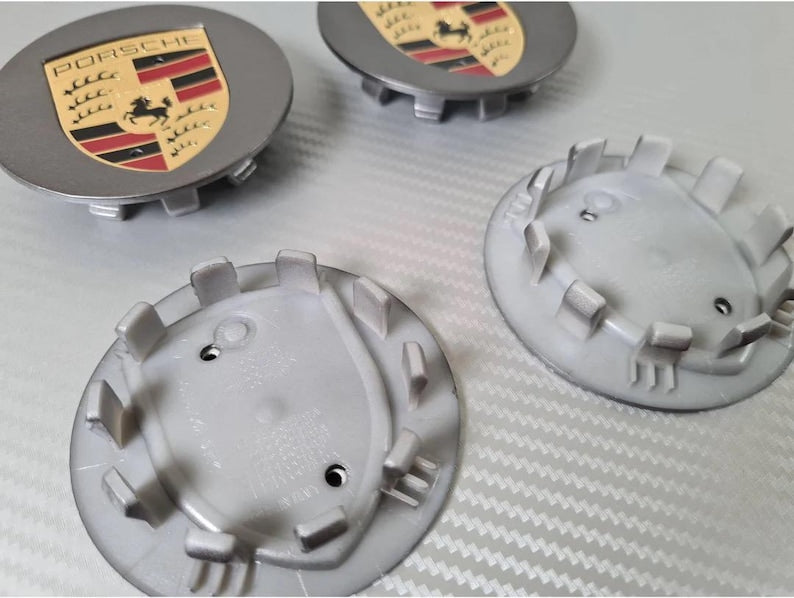Grey Porsche wheel centre caps by Eliteridegear, featuring a sleek design and official Porsche branding.