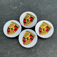 Set of four silver Porsche wheel centre caps by Eliteridegear, featuring sleek, round design with Porsche emblem detail.