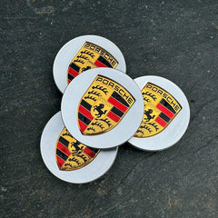 Set of four silver Porsche wheel centre caps from Eliteridegear, featuring the brand logo on a sleek round design.