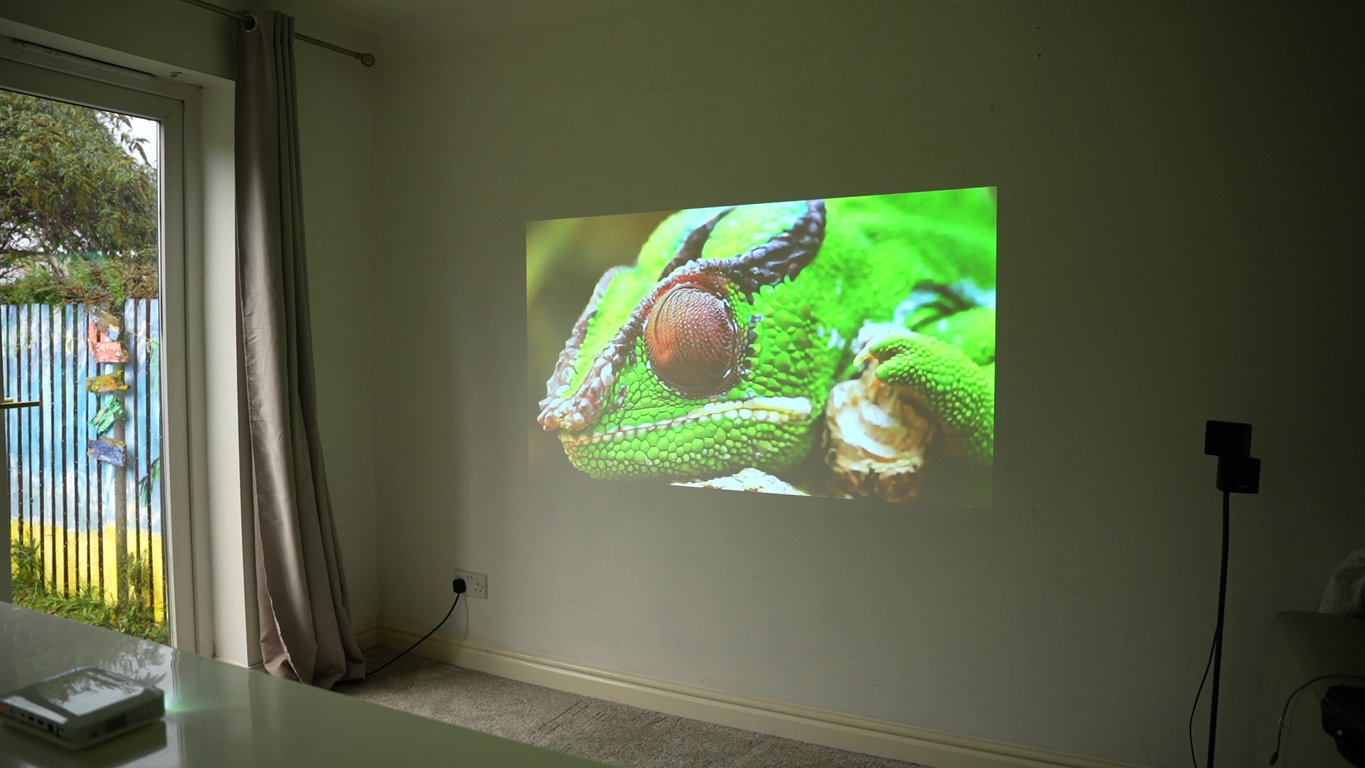 Personal Projector Pico Genie M550 Plus 4.0 smart projector showing a vibrant 1080p full HD image on a wall.